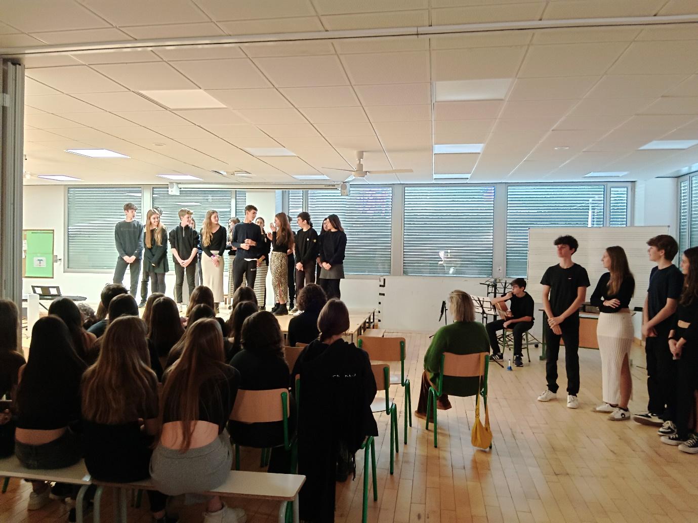 A group of people in a room with a white board
Description automatically generated